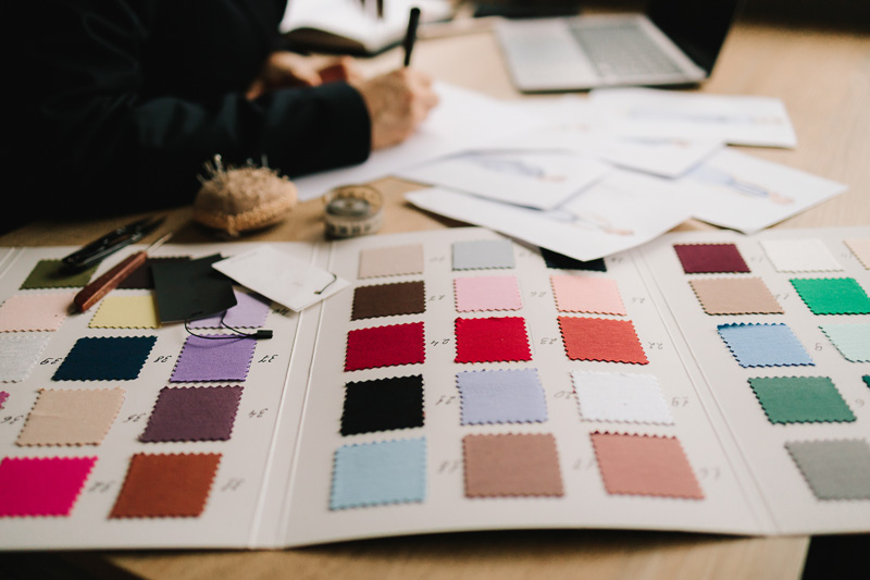 Designer plans dress designs on paper, preparing patterns and garment layouts